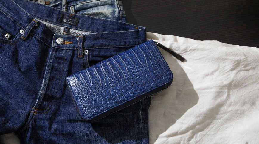 デニムジーンズと青色のクロコダイル財布