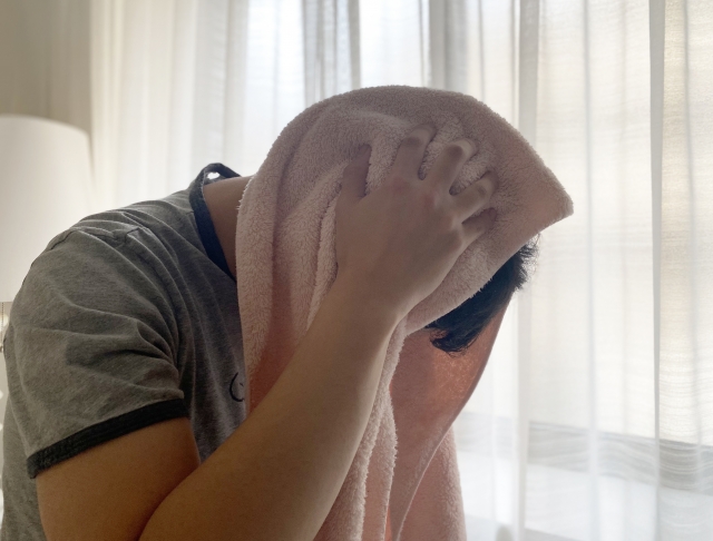 頭をタオルで拭く男性