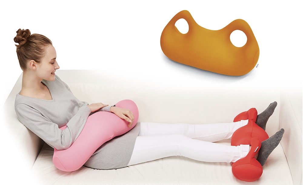 ソファの上で足を伸ばし、その足の下にビーズ枕をひいて、くつろぐ女性